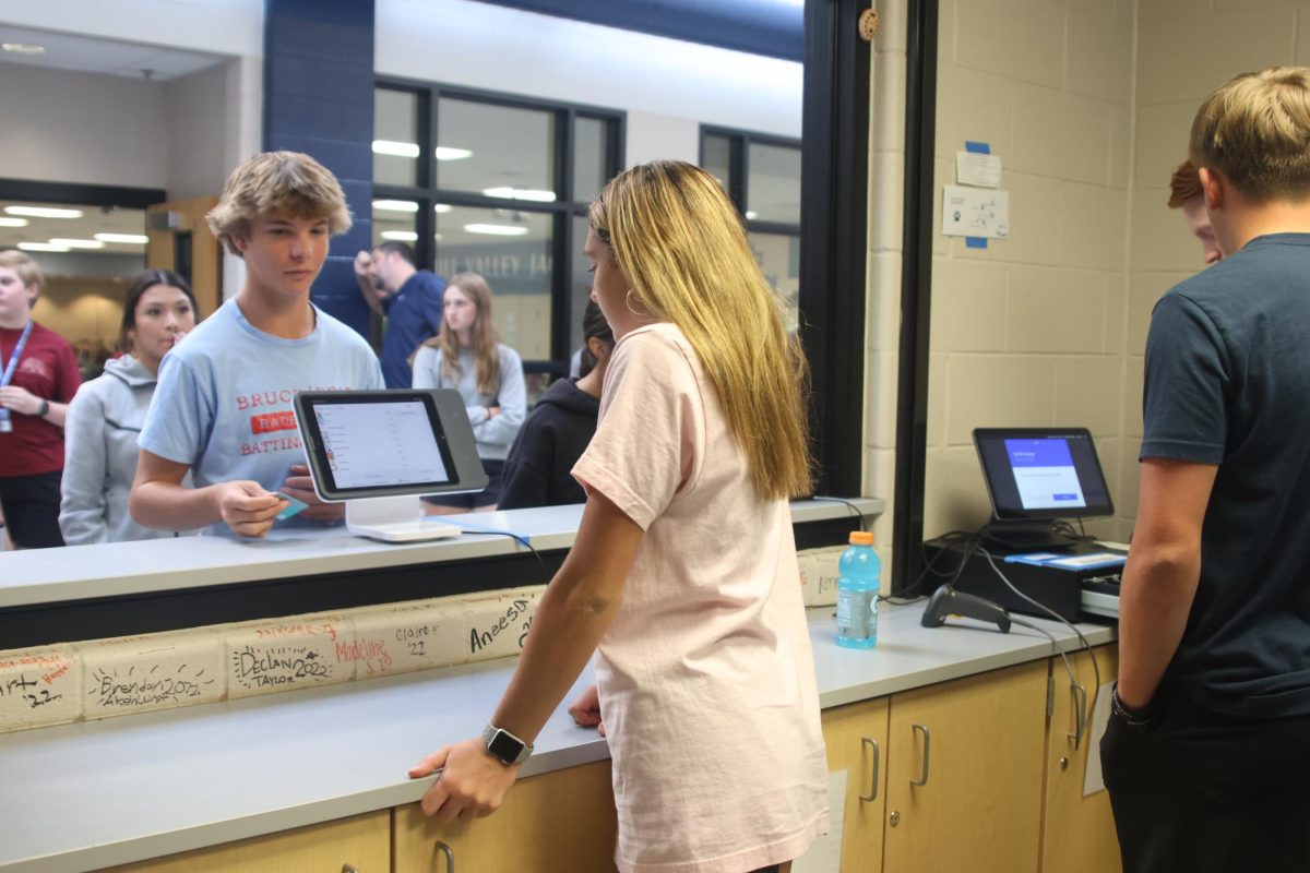 Senior Kynley Verdict checks out freshman Charlie McCall with the Catty Shacks test run Monday, Oct. 2.