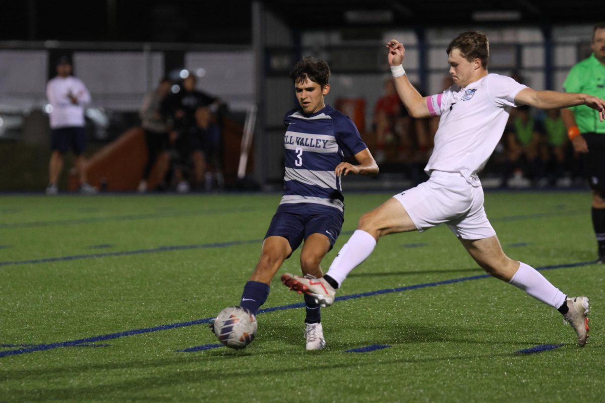 Kicking the ball away, senior Liam Watson passes the ball before the defender gets to him. 