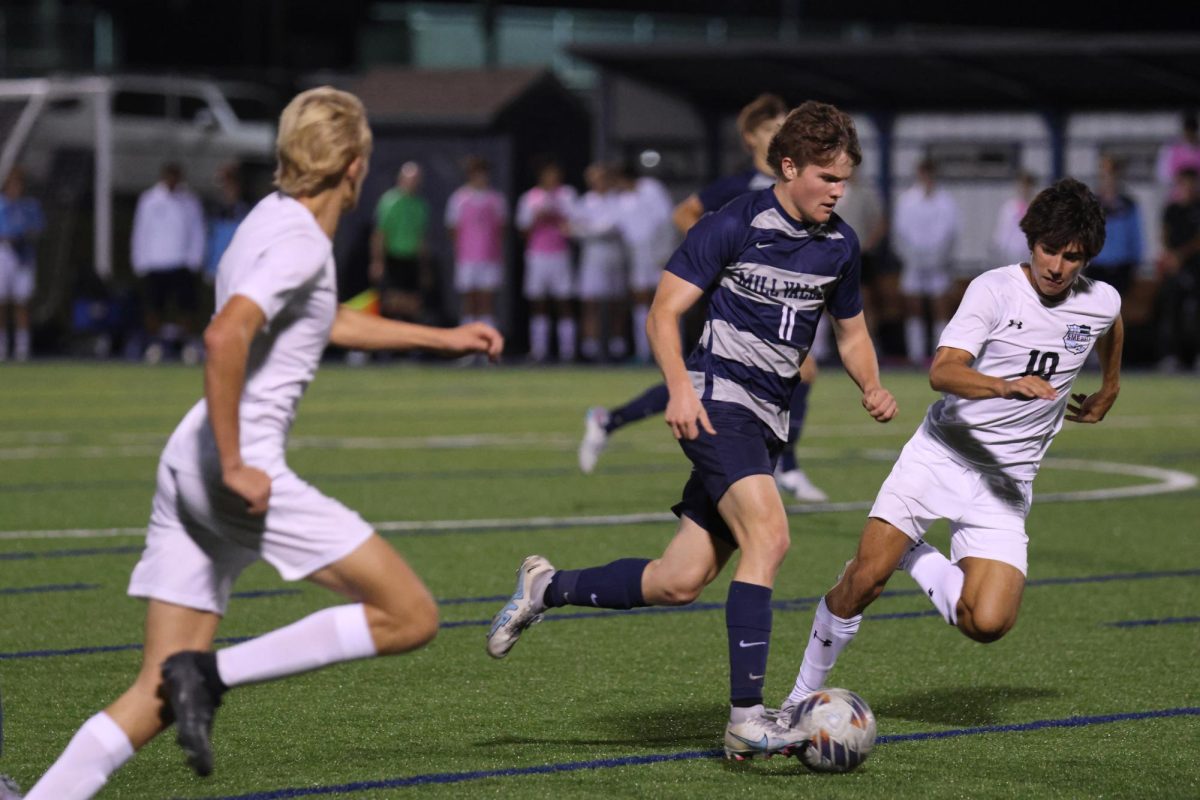 Dribbling the ball, junior Joel Hayes makes a break for goal.