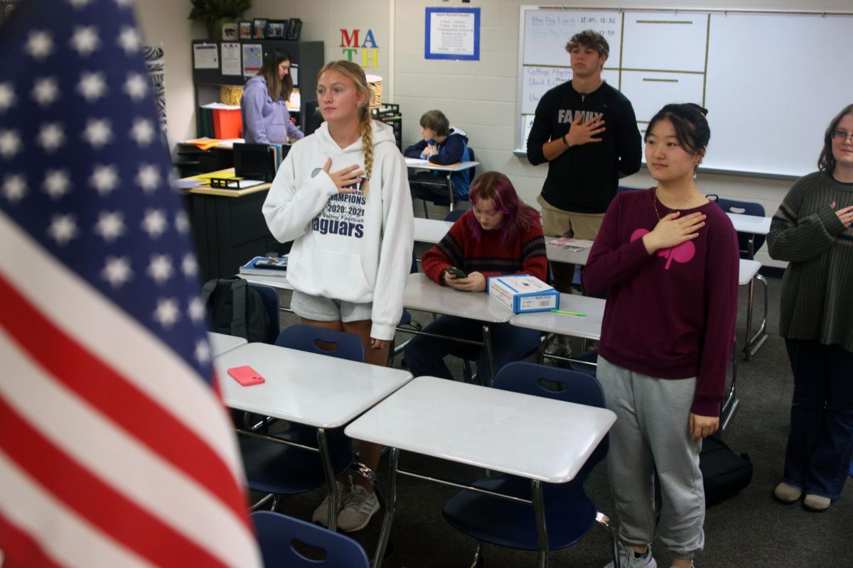 Students+in+math+teacher+Angela+Weigels+seminar+class+stand+for+the+pledge+of+allegiance+Friday%2C+Oct.+6.