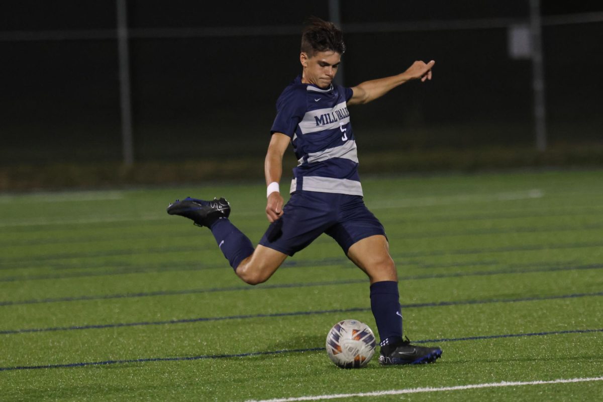 Preparing to kick the ball, senior Roman Alvarado bends his leg back.