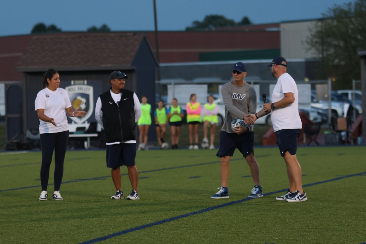 Surrounded by his fellow coaches, head coach Jason Pendleton is recognized for coaching his 800th high school varsity game.