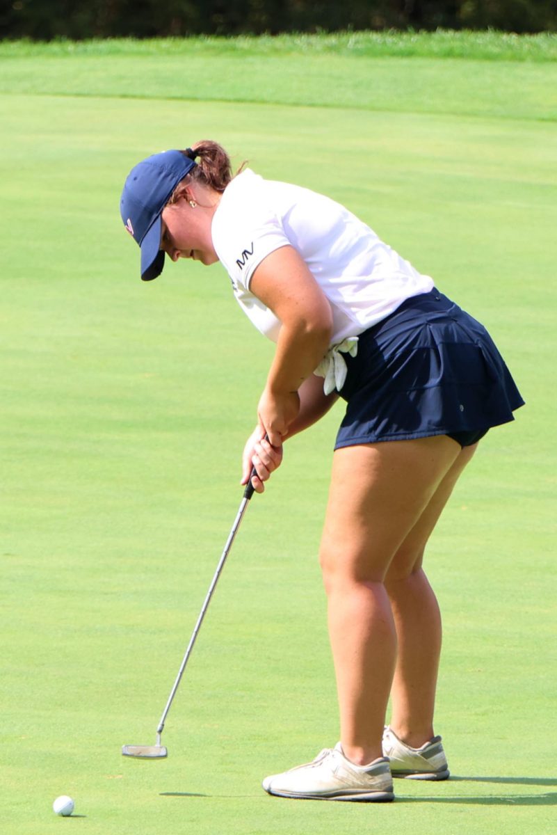 Putting the ball, senior Kathryn Yockey moves it closer to the hole. 
