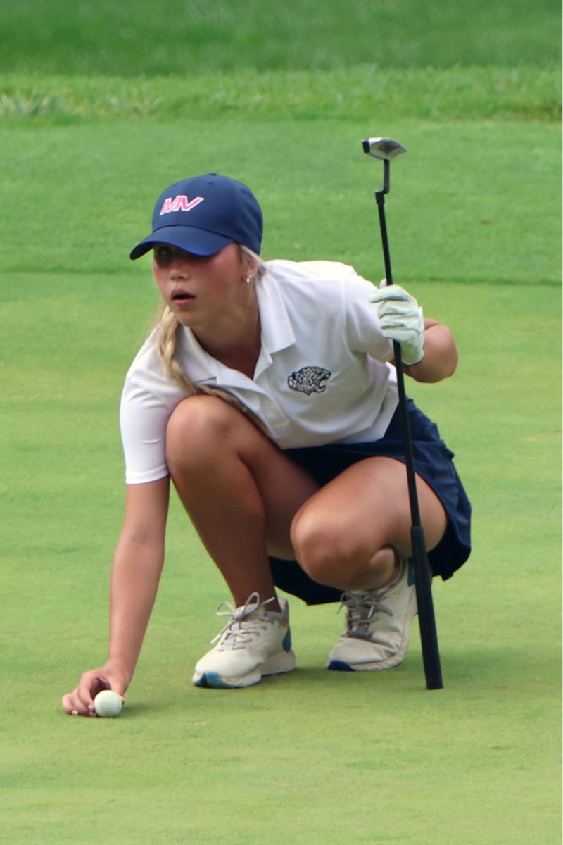 Placing the ball on the green, sophomore Sydney Epperson lines up her shot.
