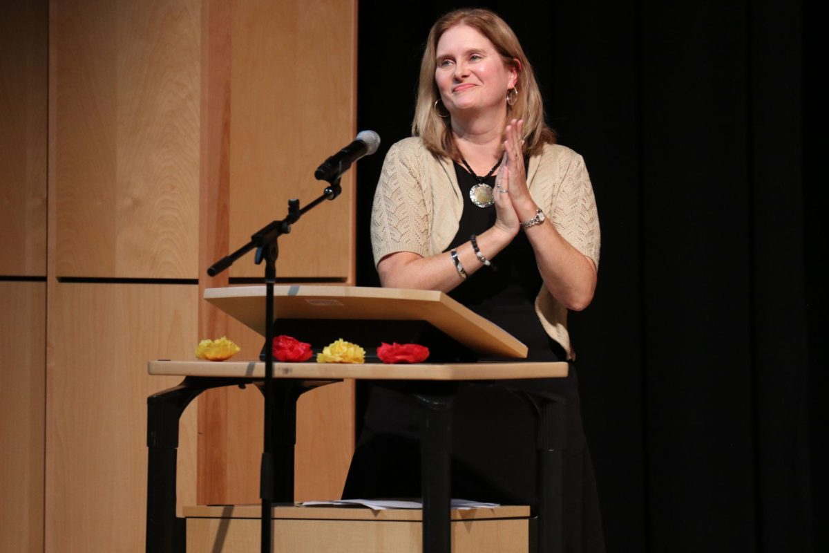 Looking at the audience, Spanish National Honors Society Sponsor Jan Good-Bollinger applauds the new inductees. 