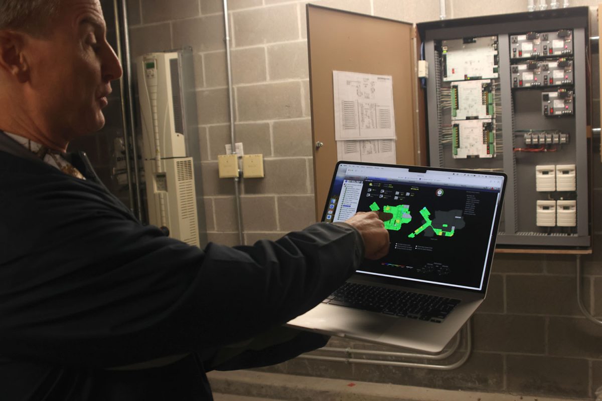 Pointing at the computer, Brian Rodkey is showing how he controls the temperature in the school.