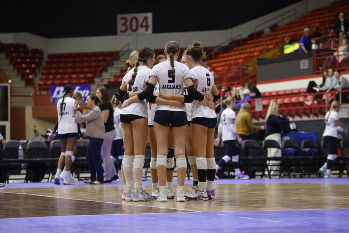 Before the second set against Manhattan, the team huddles together.