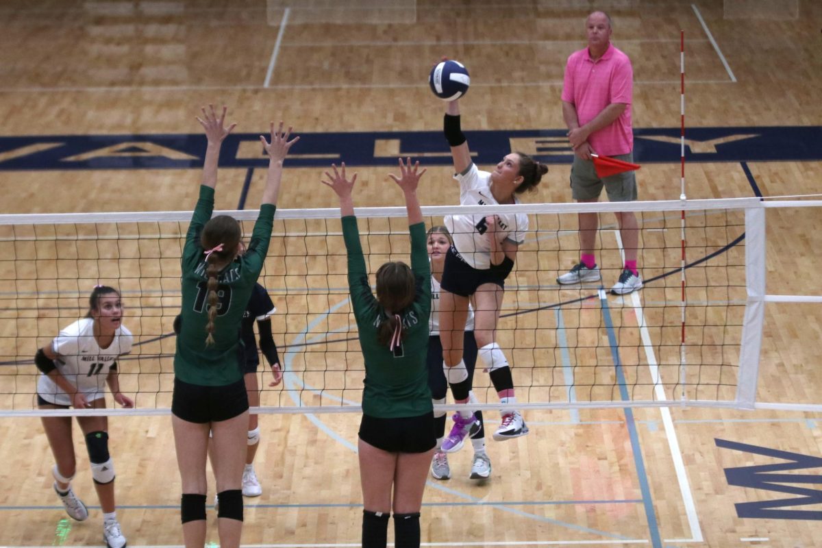 Reaching with her arm up, senior Kaitlyn Burke makes the kill against Desoto.