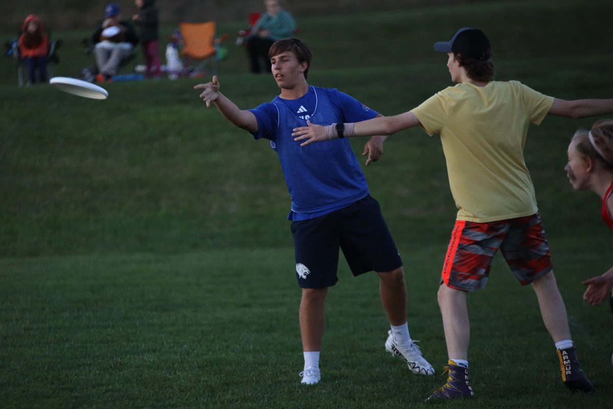 Finding an opening, sophomore Jack Thomas tosses the frisbee to his teammate. 