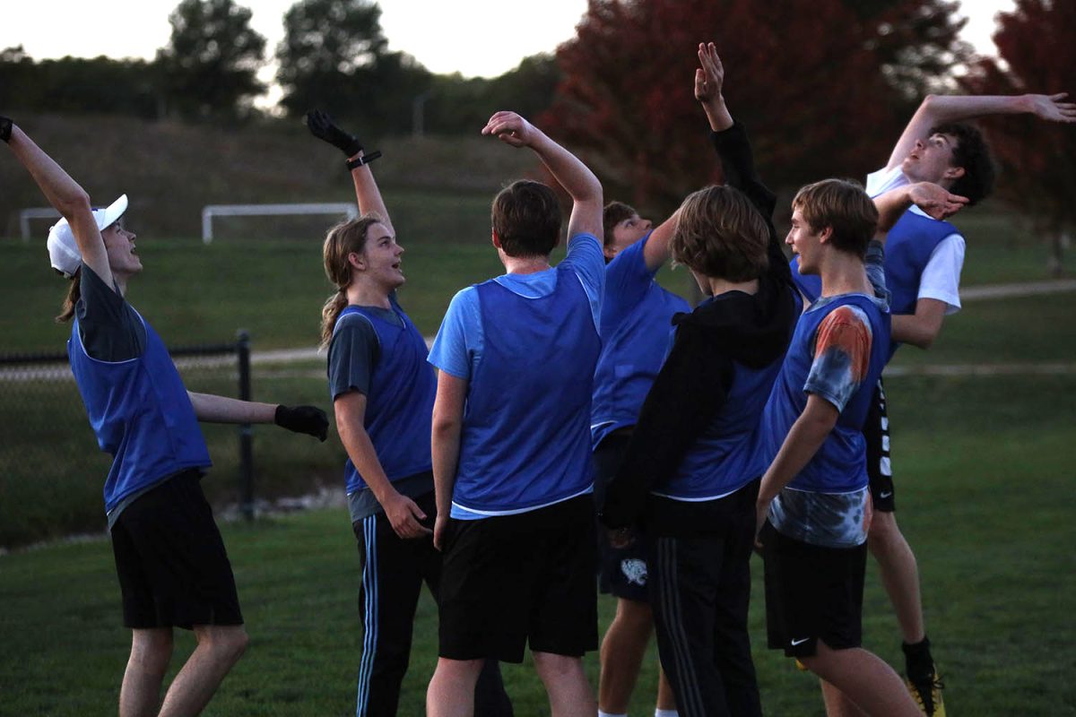Throwing their arms up, the team gets hyped during a water break.