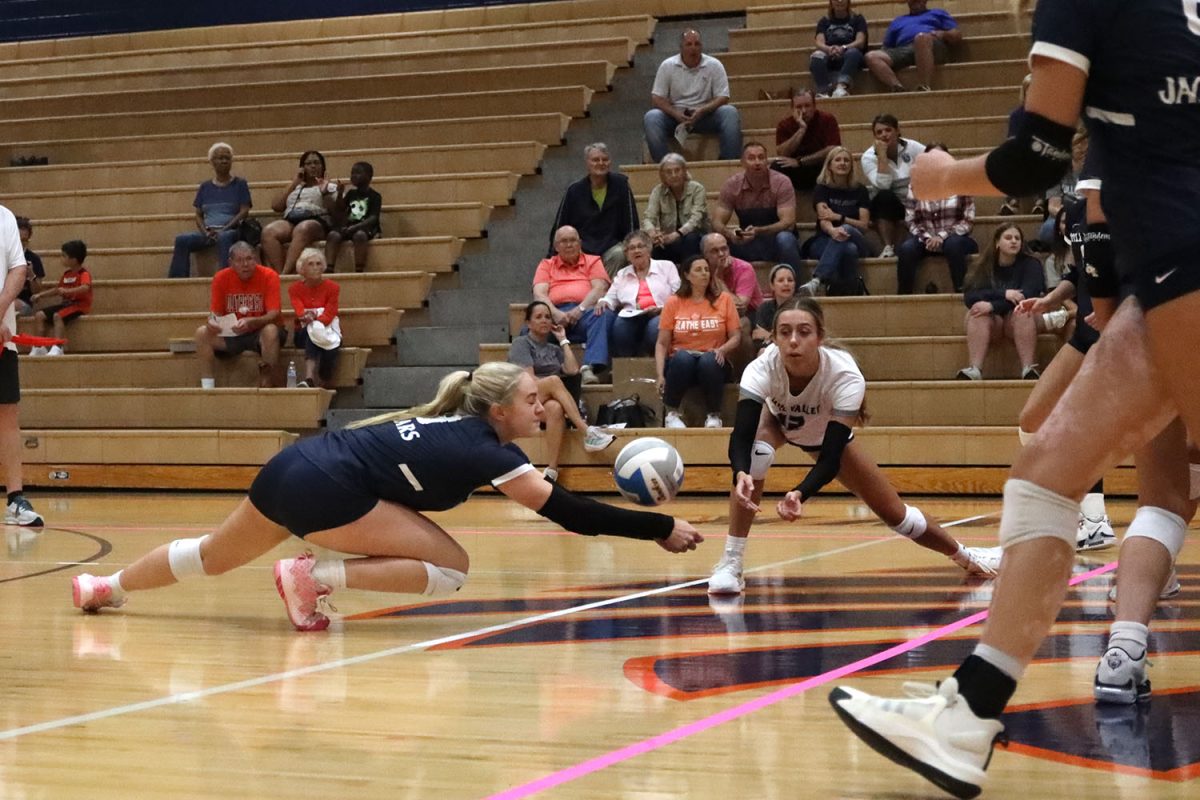 Making a pass, freshman Riley Riggs hits the floor.
