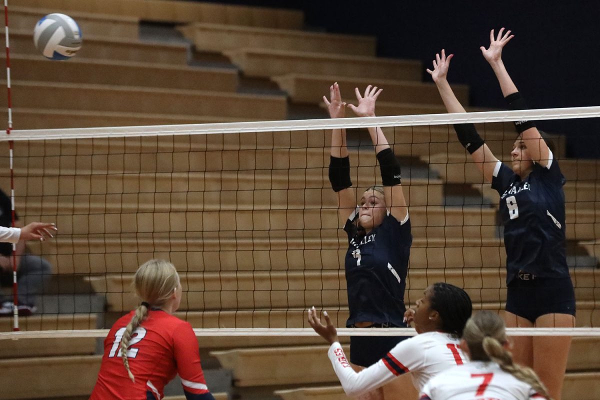 Jumping to defend at the net, juniors Brekhan Waters and Ashlyn Blazer make a block.