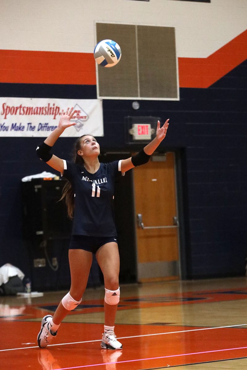 Eyes on the ball, sophomore Ella Florez serves the ball over the net.