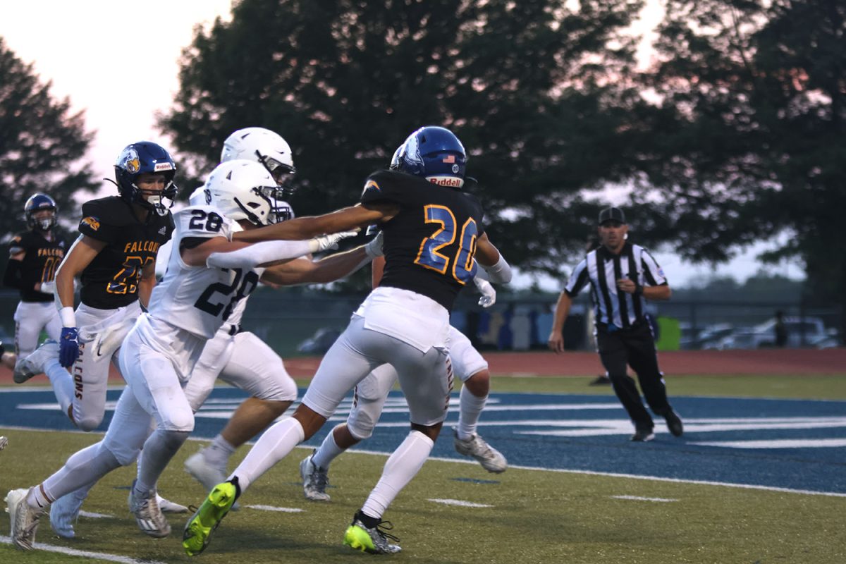 Wide receiver Andy Watts pushes through the Falcons in the way of the end zone.