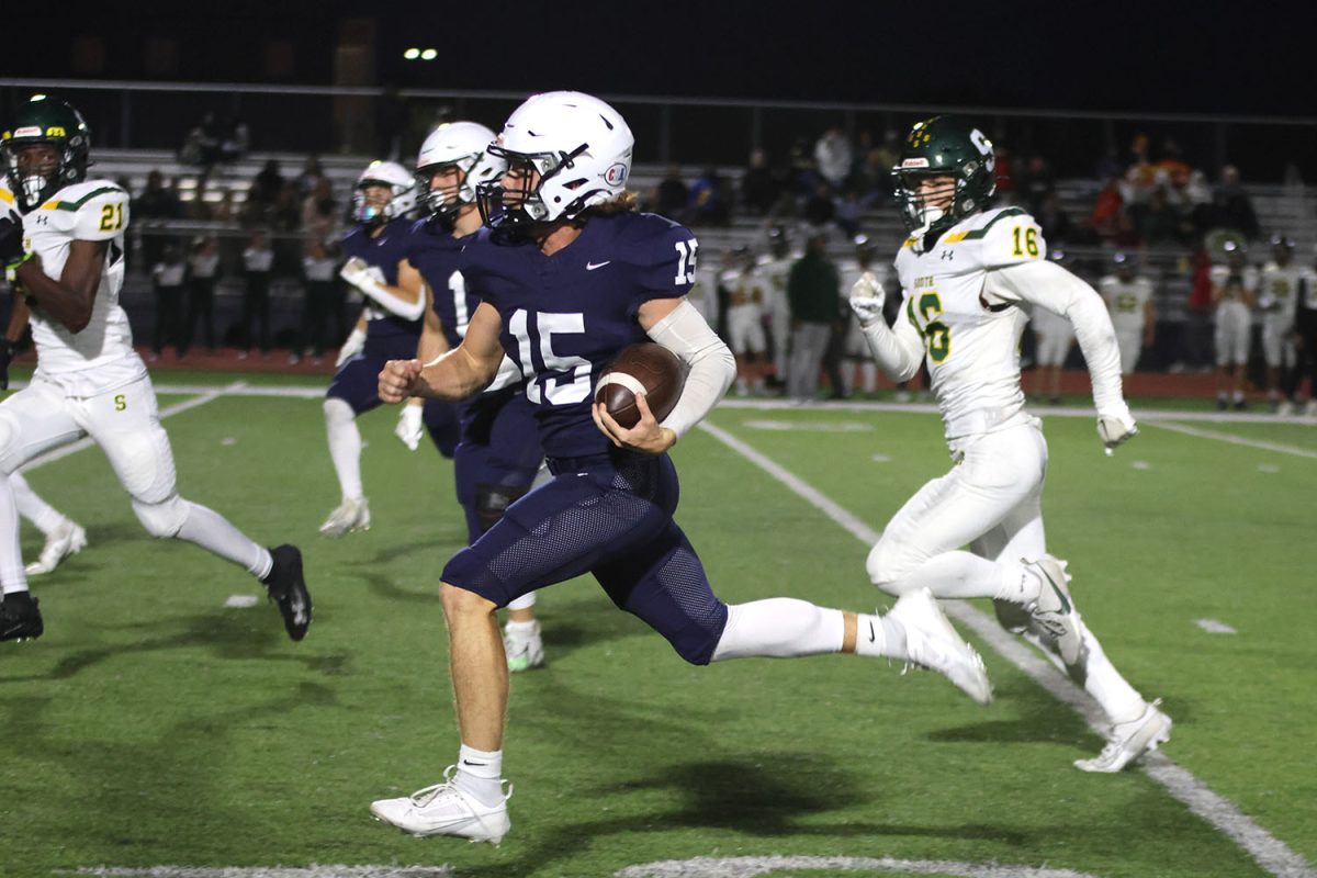 On his way towards the end zone in pursuit of a touchdown, senior quarterback Daniel Blaine evades the defense of Shawnee Mission South.