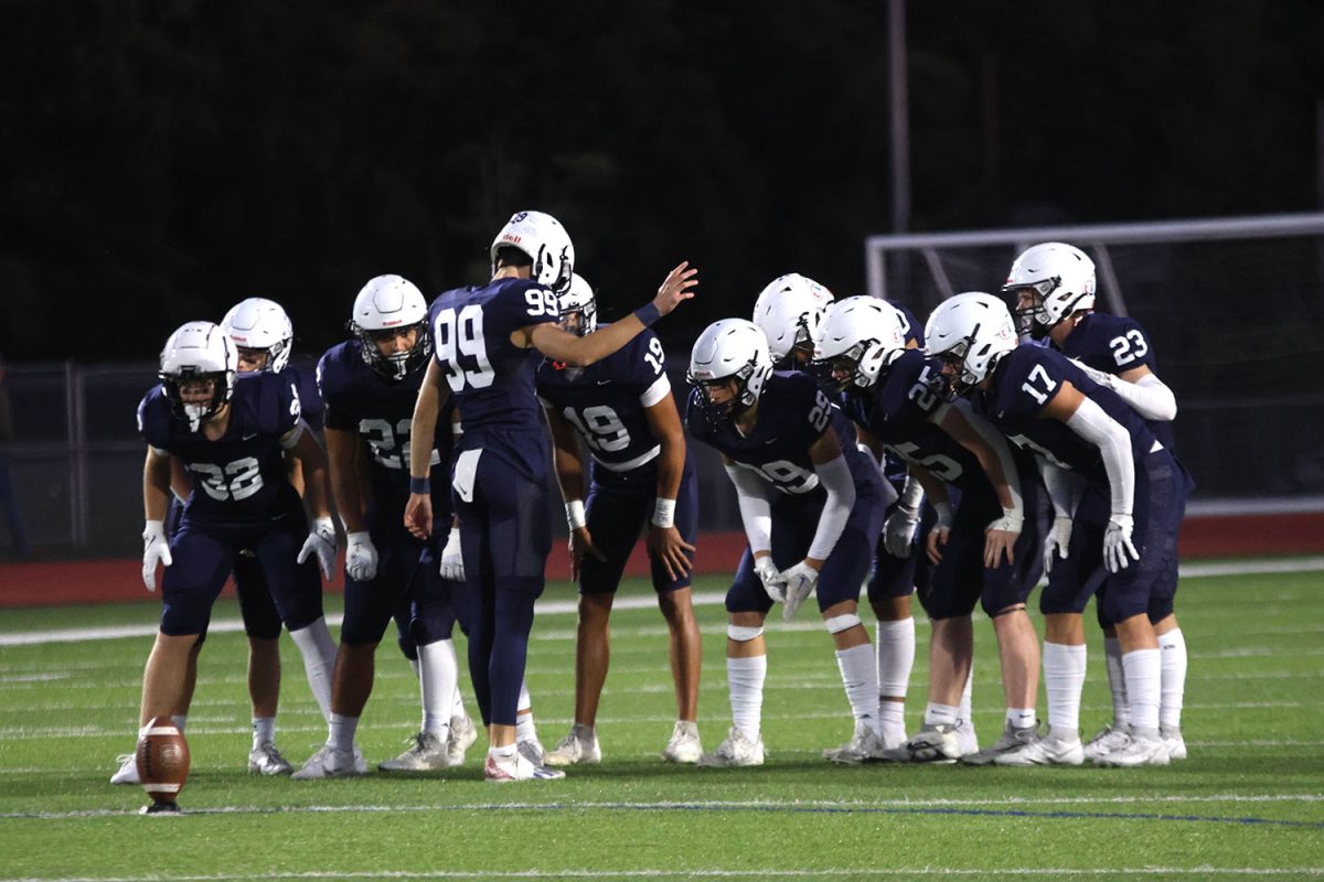 Prior to the beginning of the second half, senior kicker Kenten Laughman directs the team on the plan of action.