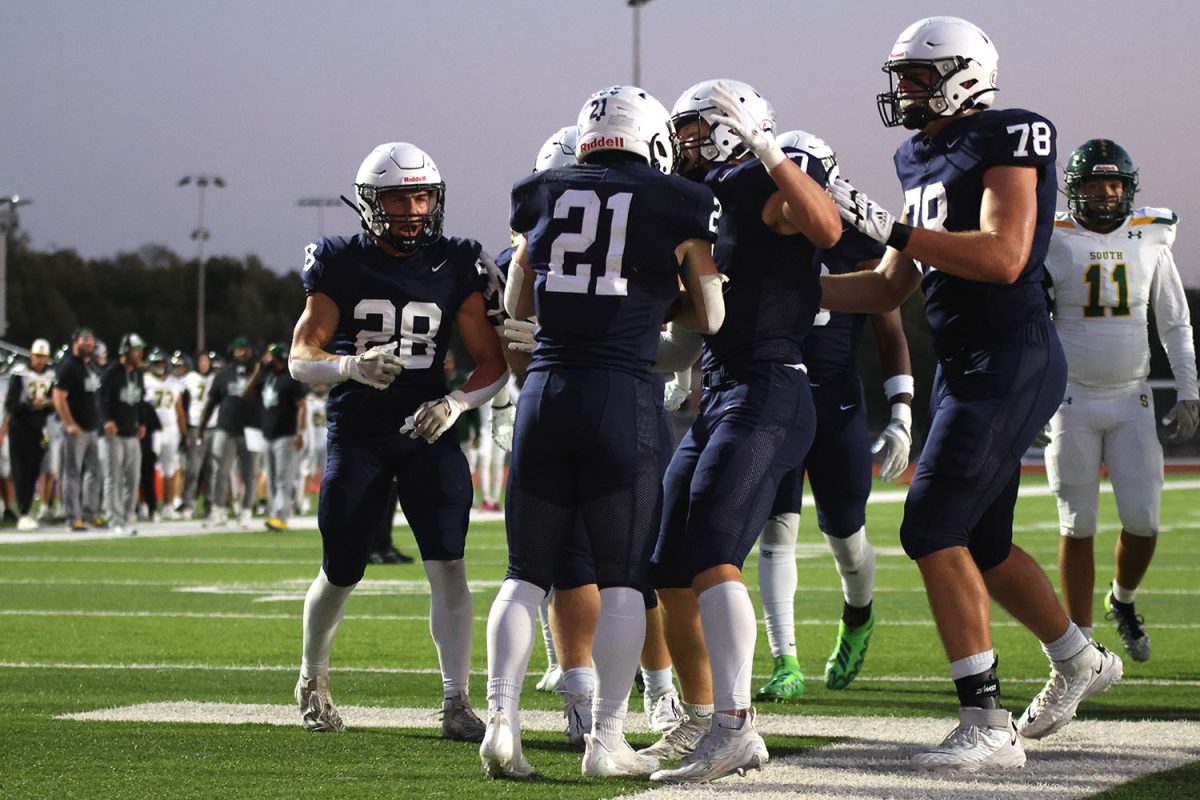 Celebrating a touchdown in the first quarter, Mill Valley offensive players cluster around each other.