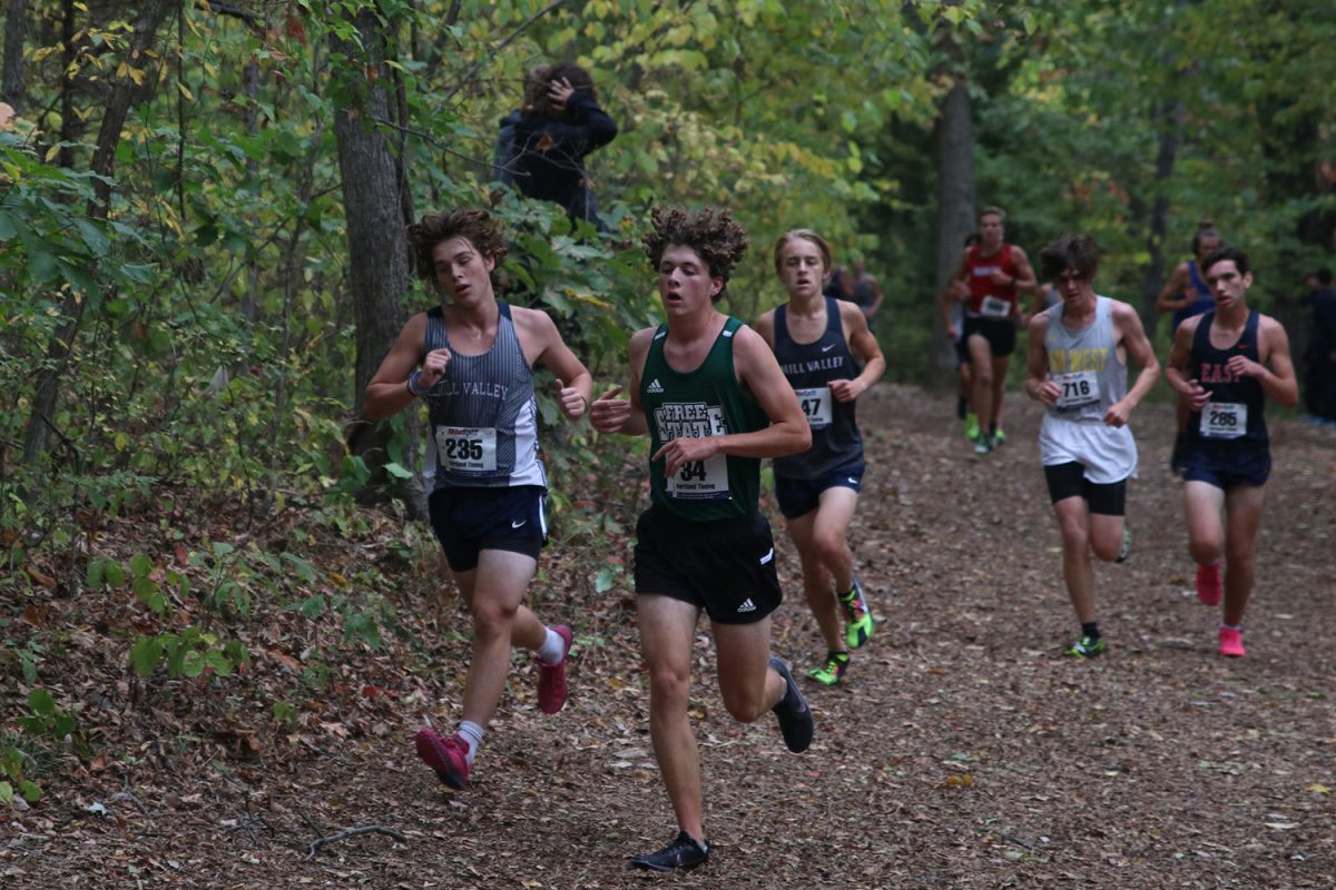 Racing to pass his competition, junior Thomas Helm strides out during the race.