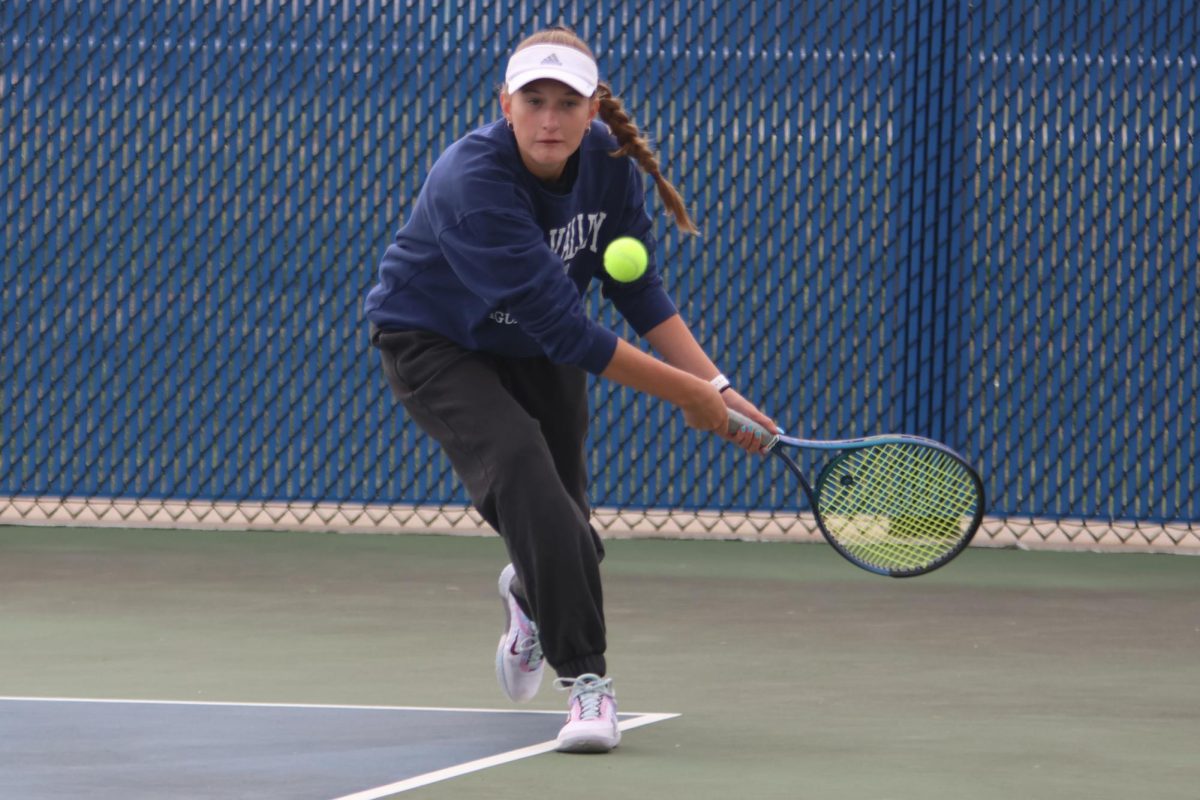 Using two hands, junior Stella Platt gets ready to hit the ball before it goes out. 