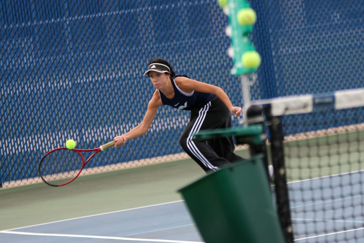 Stretching her arm, sophomore Heidi Baillos saves the ball from going out.