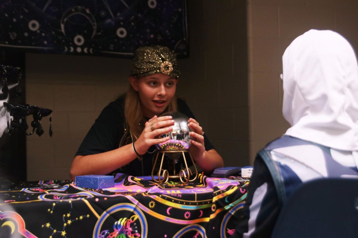 Looking up, sophomore Sienna Suderman predicts the future at the future telling station. 