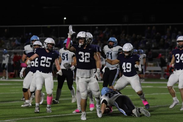 After the play, junior Garret Clark shows “landshark” to the team and crowd.
