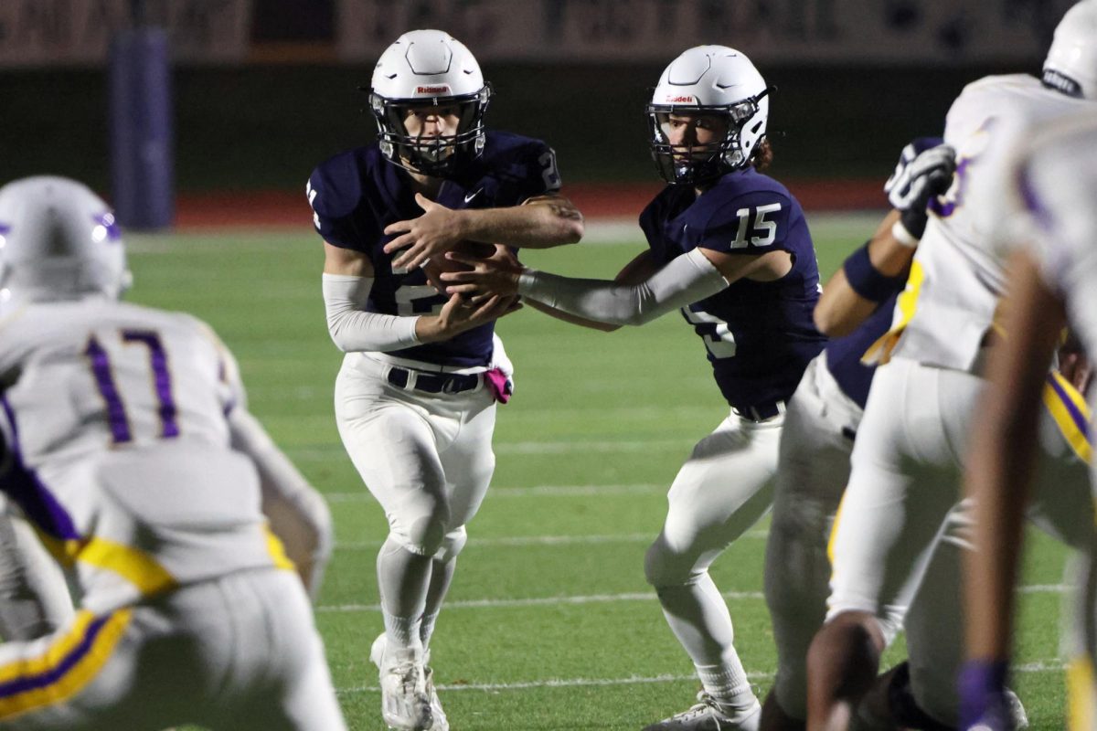 Senior Daniel Blaine hands the ball off to senior Tristan Baker who would then run the ball in for a touchdown.