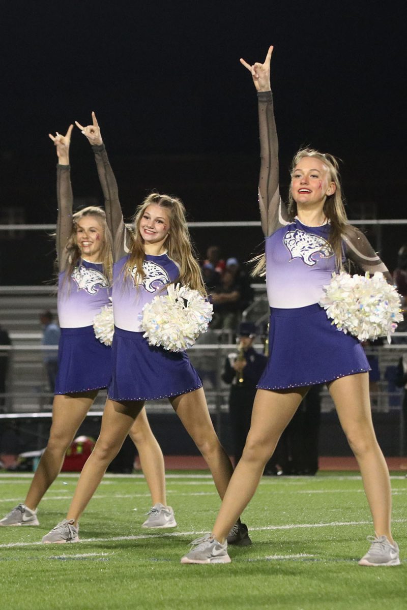 With big smiles, senior Halle Wampler and sophomores Ella Jones and Preslie Wampler put their hands in the air.