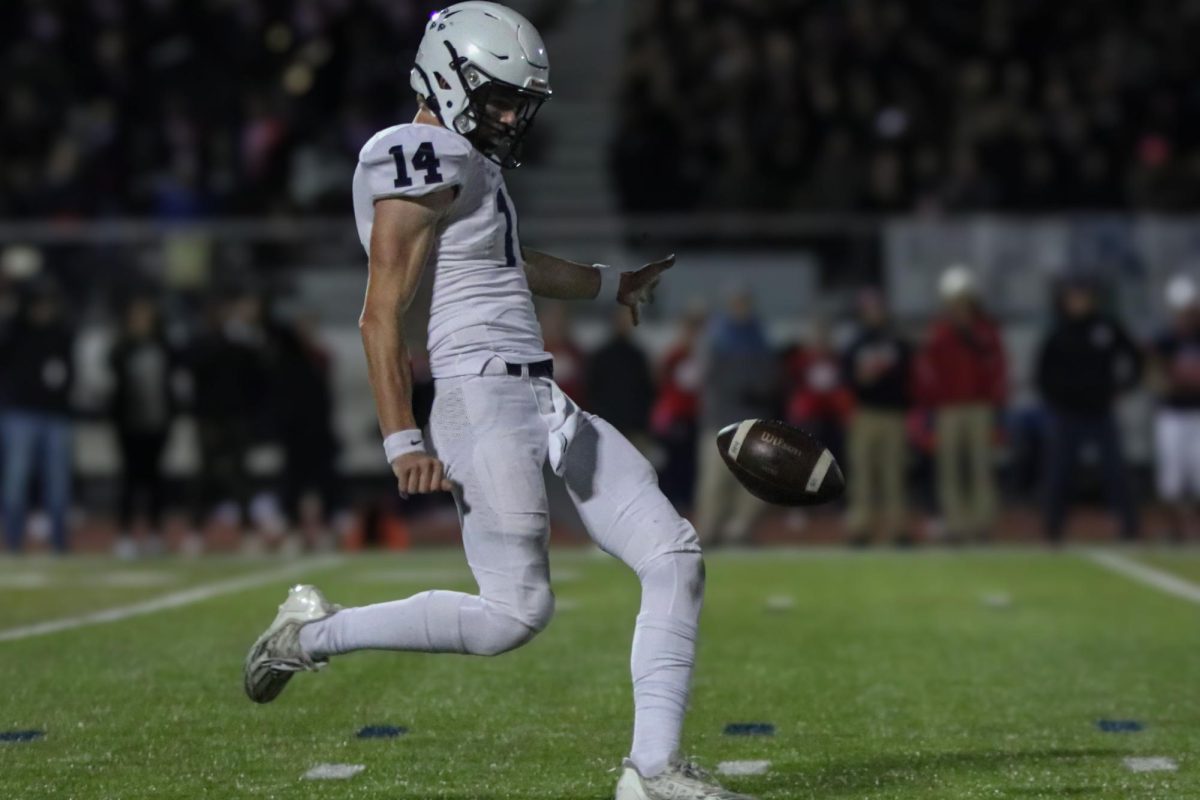 With his leg back, junior Connor Bohon punts the ball.