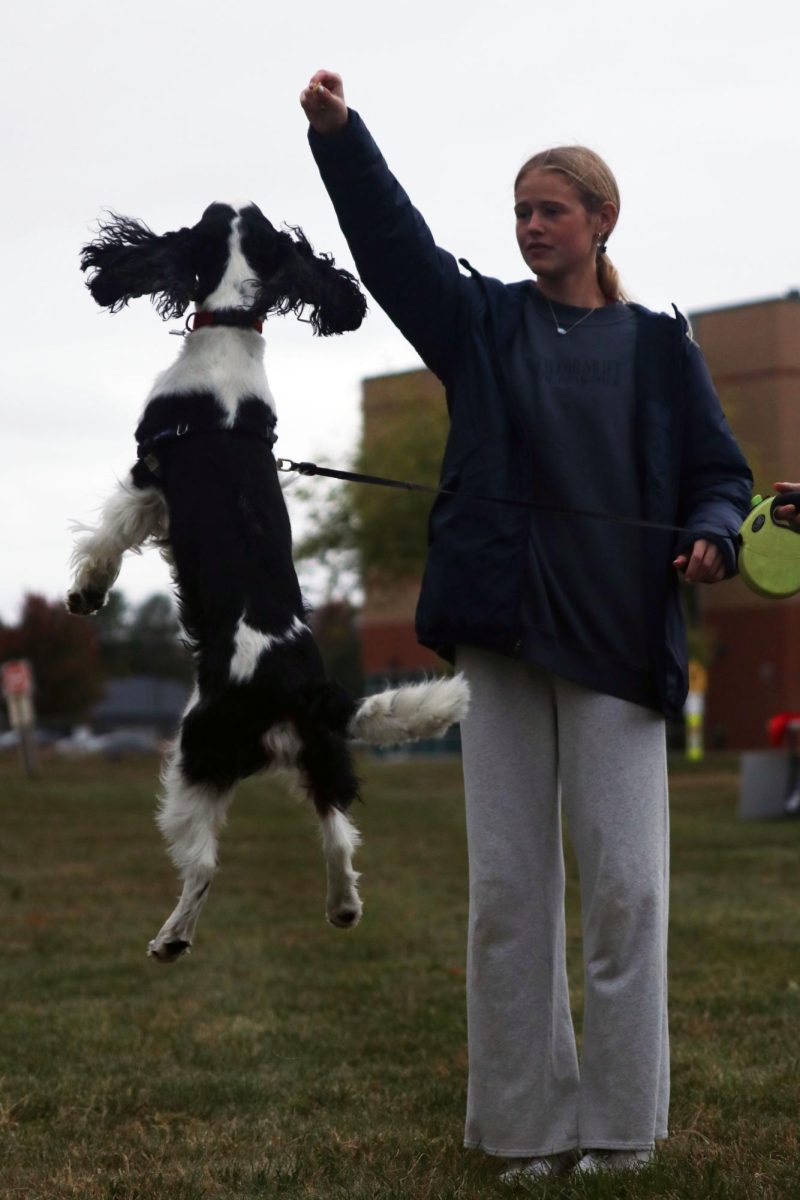Showing off her dog’s best trick, junior Calista Marx holds up a treat for her dog to catch.

