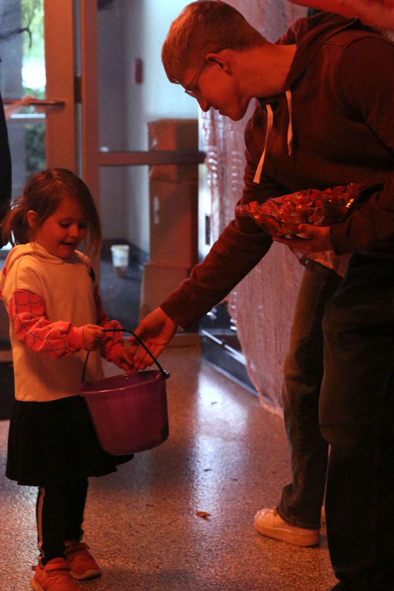 Senior Cooper Line gives candy to kids walking through the door.