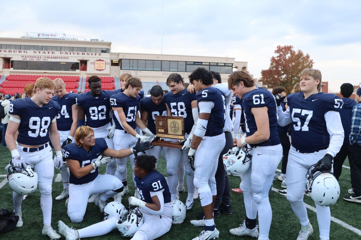 The lineman pose for a picture with the 5A state championship trophy. 