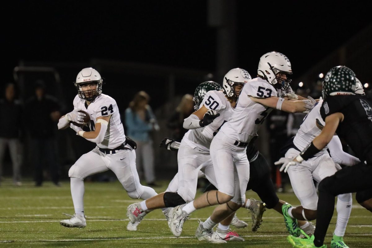 Senior Jaden Scobee protects the ball while going around the defender.