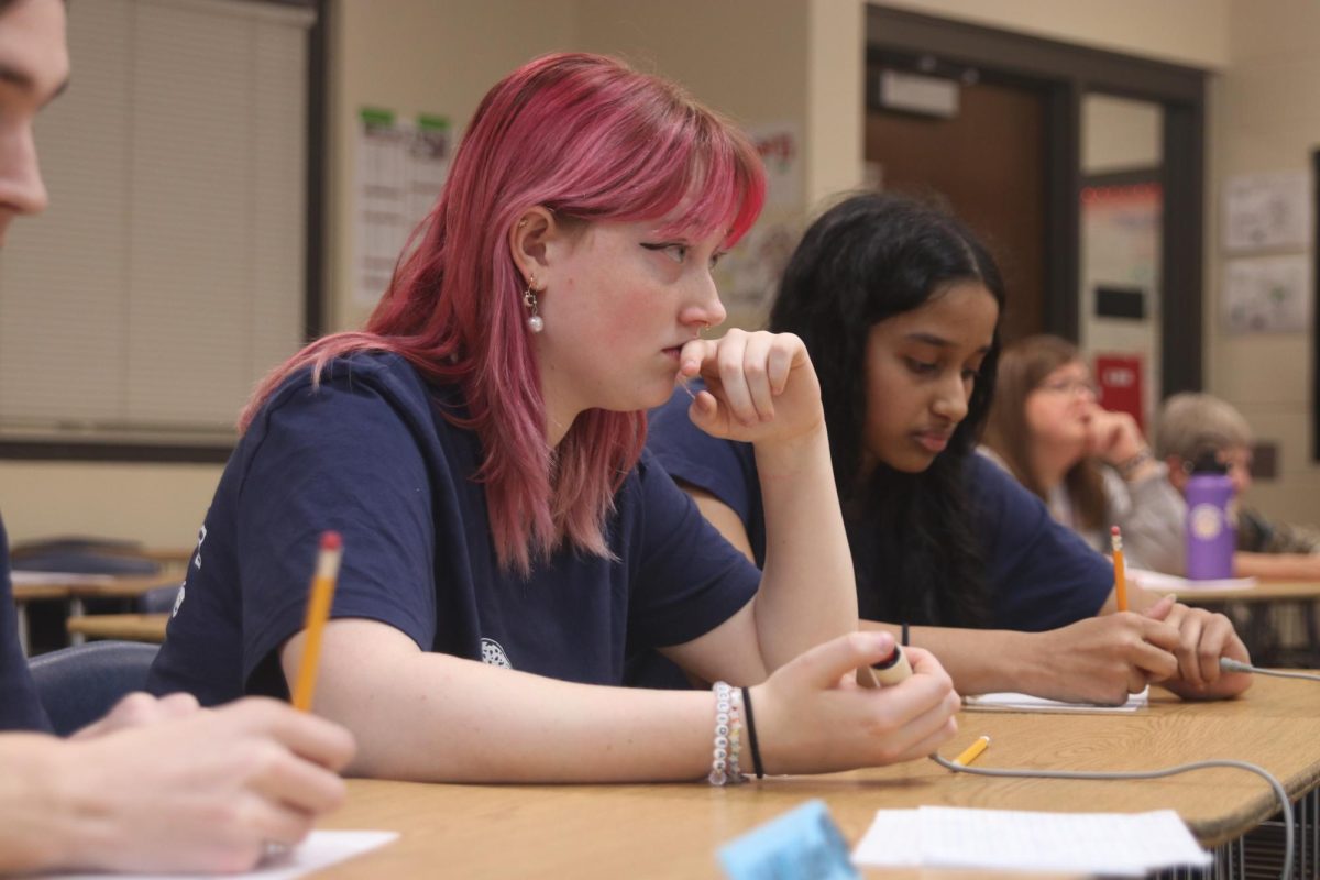 Ready to buzz in, senior Emma Clement listens as the moderator reads the question. 