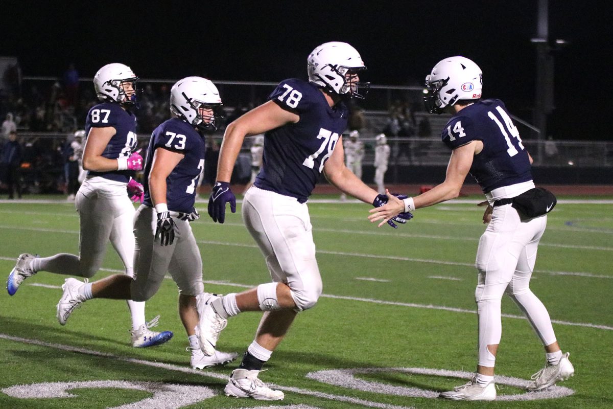 With a successful touchdown by the Jaguars in the third quarter, junior quarterback Connor Bohon congratulates senior offensive lineman Gus Hawkins on a good play.