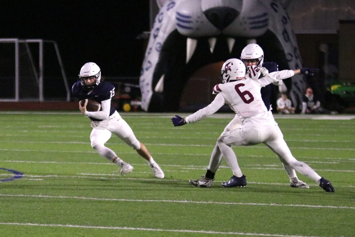 Evading the defensive line, senior quarterback Daniel Blaine weaves towards the endzone following a turnover.