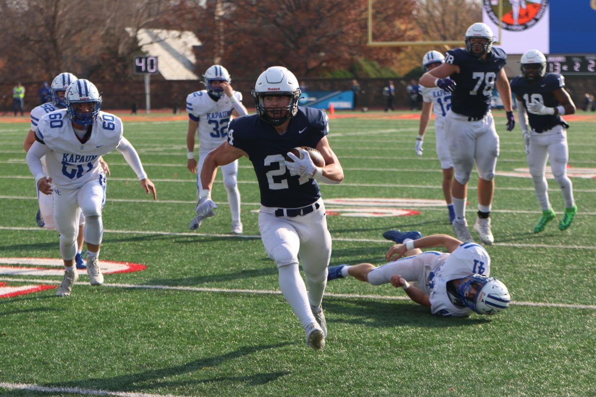 Senior Jaden Scobee runs towards the endzone as defenders fall behind him. 