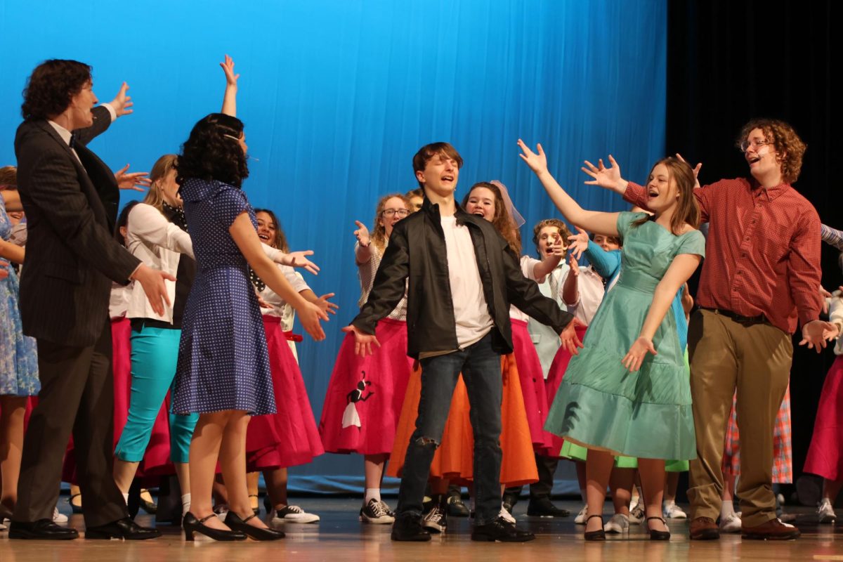 Arms out, Conrad Birdie, played by Drew Cormany, sings along to “Bye Bye Birdie” during curtain call.