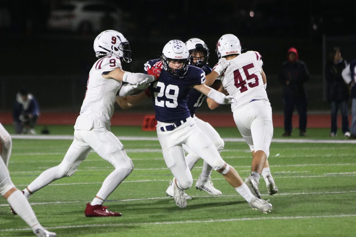 With his hands out, junior Braden Peter rushes through his opponents.