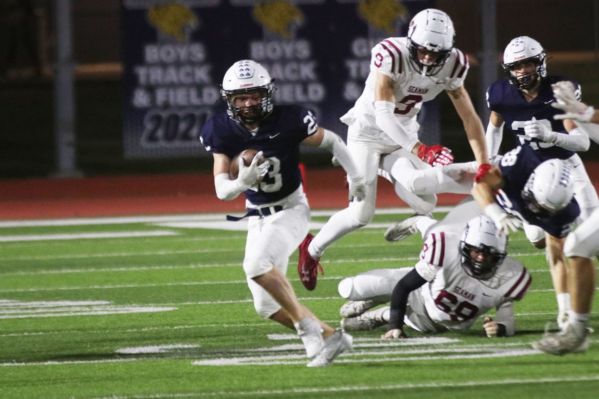 Looking ahead, junior Clayton Sondgeroth paves his way to attempt a touchdown.