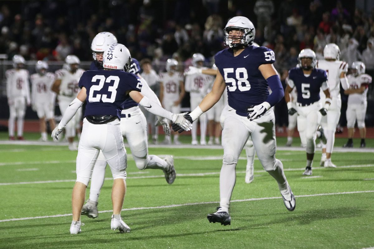 Smiling, juniors Abram Shaffer high fives Clayton Sondgeroth share a high-five.