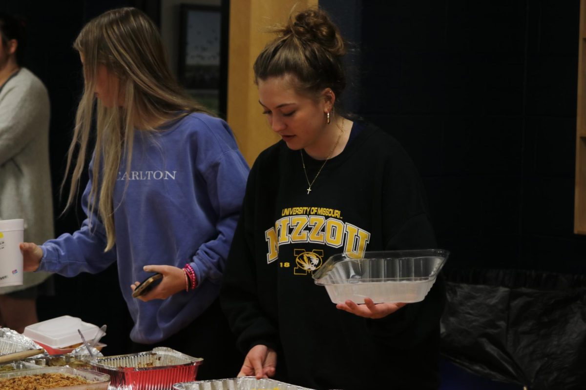 Focused, junior Gracie Kurzejeski prepares food for club members.
