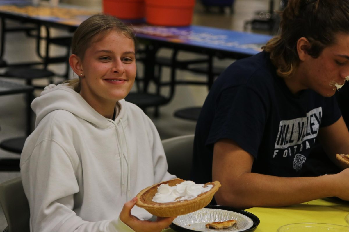 Smiling, sophomore Sienna Suderman tries to finish her pie during the pie eating contest.
