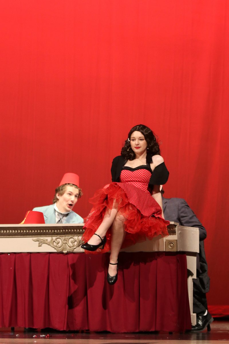 Sitting on the table, Rose Alvarez, played by senior Grace Cormany, poses while performing to “Shriner Ballet”.