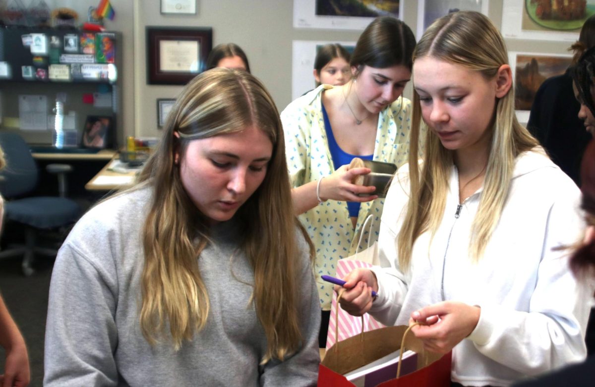 Seniors Jenna Tuttle and Madison Angell decide what to put inside one of the adult gift bags at the Youth for Refugees and National Honor Society gift bag event Friday, Nov. 17.