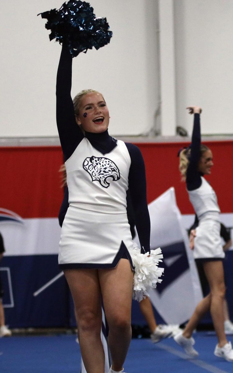 Preparing for the next cheer, freshman Olivia Pearce smiles.
