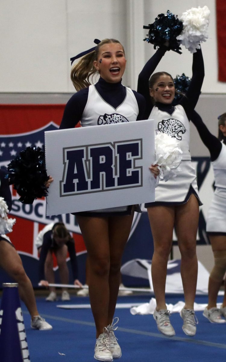 Holding the sign, sophomore Sydney Epperson prepares for the next cheer.
