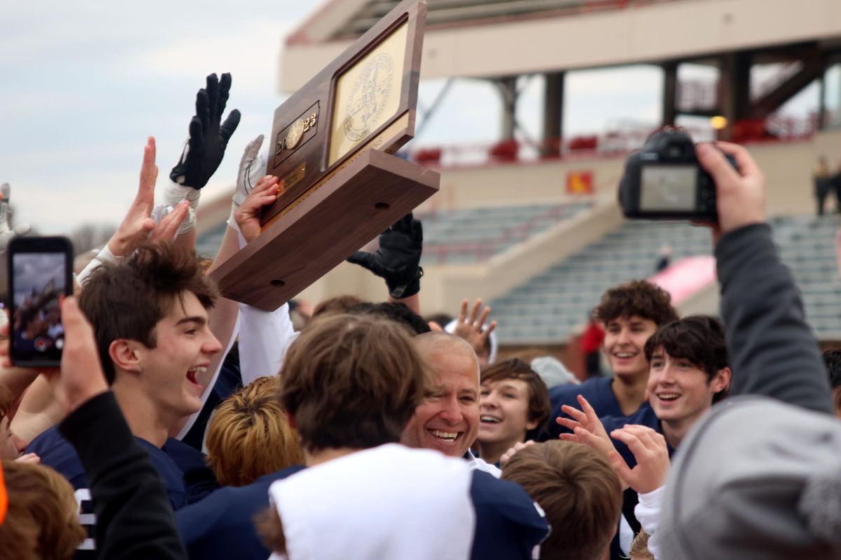 After receiving the trophy, head coach Joel Applebee celebrates with the team and community.