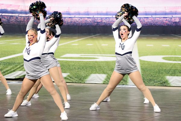 Posing during their routine, senior Trinity Baker and junior Josie Mason put their arms in the air.