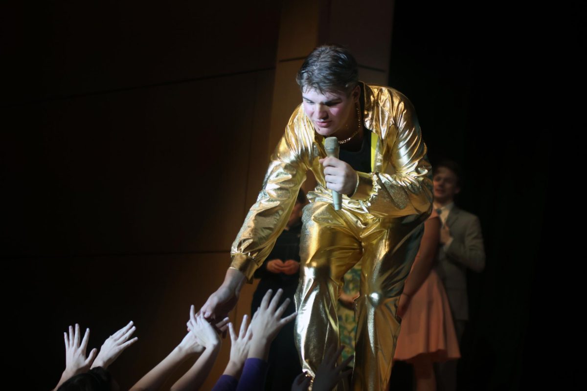 Reaching out to the fans by the stage, Conrad Birdie, played by senior Blake Powers, performs “Honestly Sincere”.